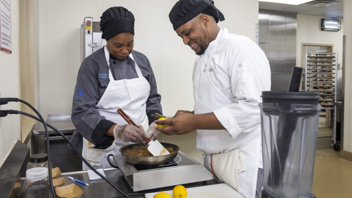 Teacher and student of the Culinary program cook a meal together in the kitchen